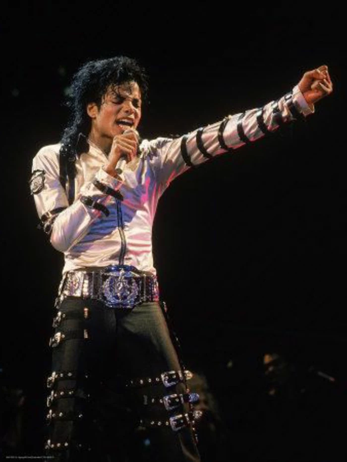 80s fashion trends, Michael Jackson holding microphone and singing, eyes closed one hand stretched out in fist, white shining zip-up shirt, black leather trousers