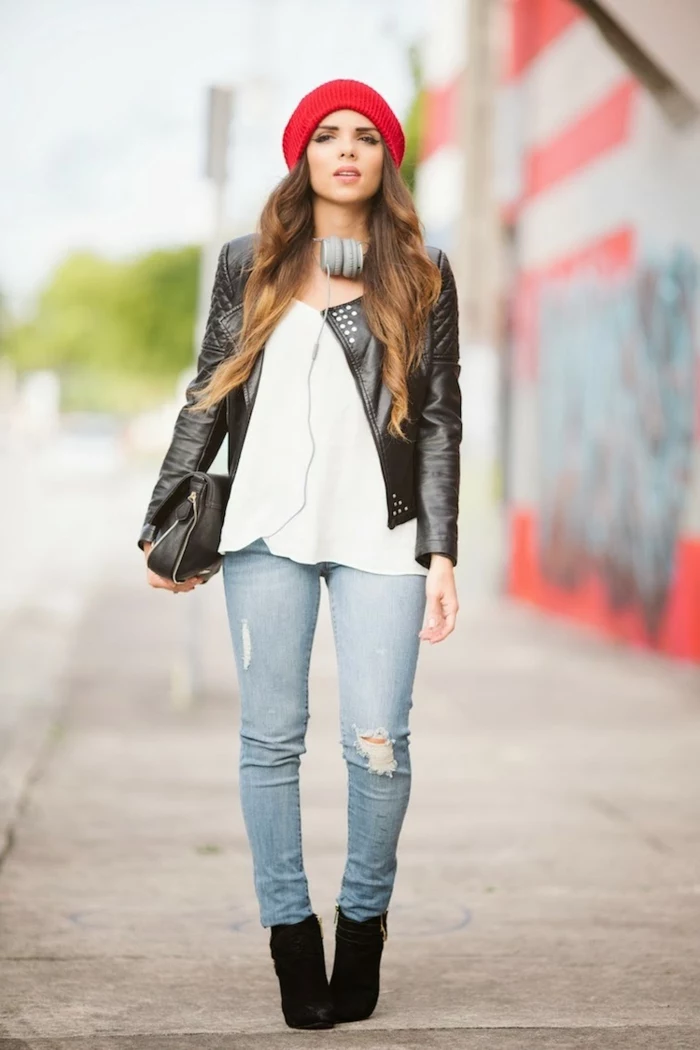 casual business attire, distressed jeans and white top, black biker leather jacket and black bag, worn by woman with long brown ombre hair, red beanie hat headphones and black shoes