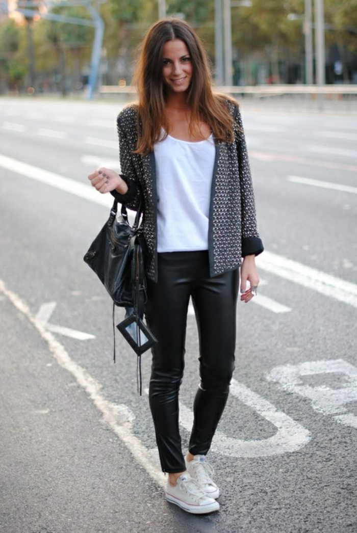 women's business attire, smiling brunette in black leather skinny trousers and white top, with dark grey cardigan, black leather bag and white sneakers