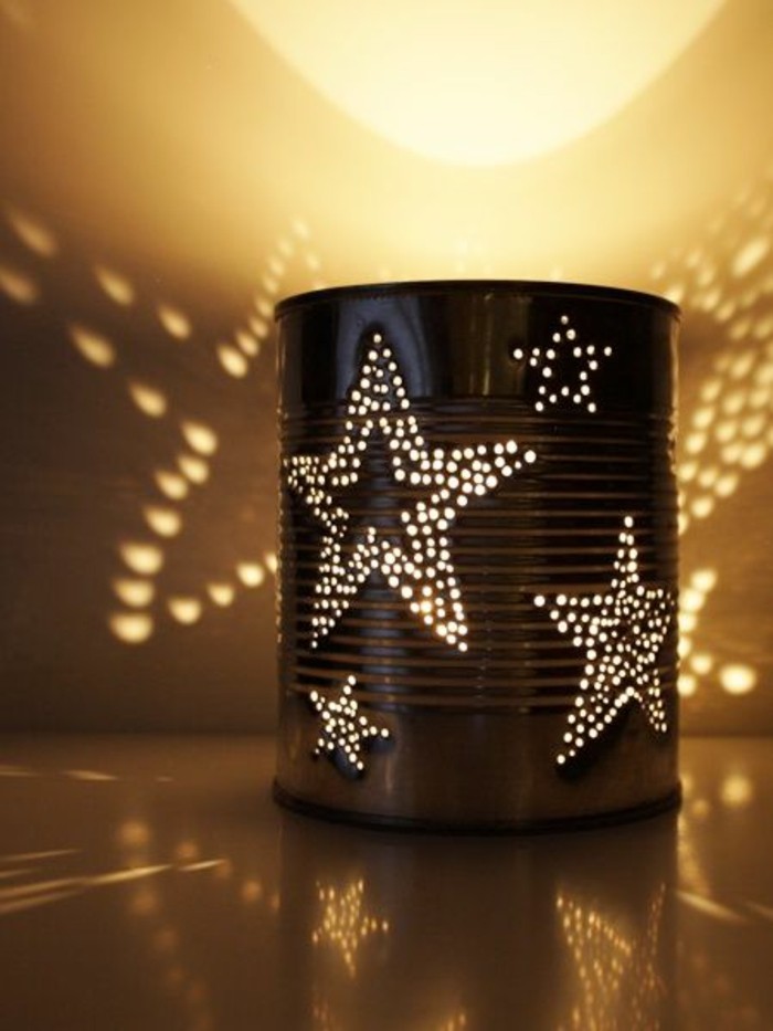luminary made from tin can, with little holes forming star patterns, light from within projects star patterns on surface and wall