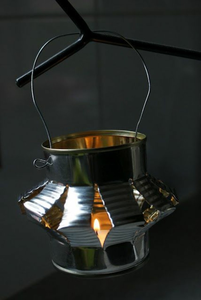 lantern made from cut and folded plain tin can, hanging from a wire handle, containing small lit candle