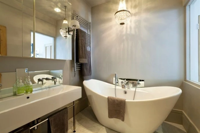 bathroom remodel, white ceramic tub, big white sink, mirrored cupboards and chandelier 