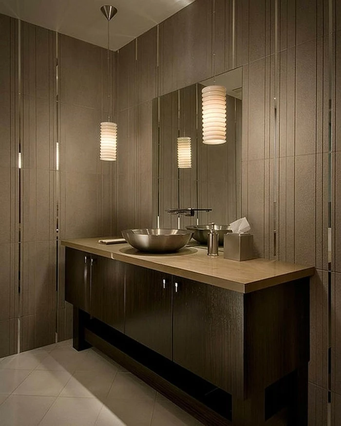 bathroom renovations, room with brown walls with mirror details, large brown cupboard with round metal sink, wall mirror and two hanging lights