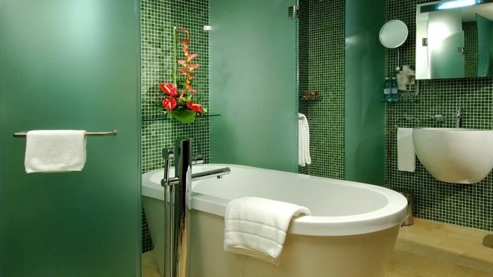 bathroom designs, walls with tiny green tiles in different shades, white ceramic tub and sink, shower cabin with green matte opaque glass