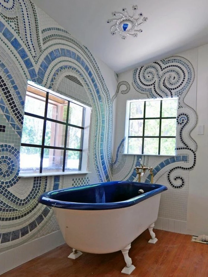 bathroom designs, room with wooden floor, mural made from tiny blue stones in different shades on walls, white and dark blue tub