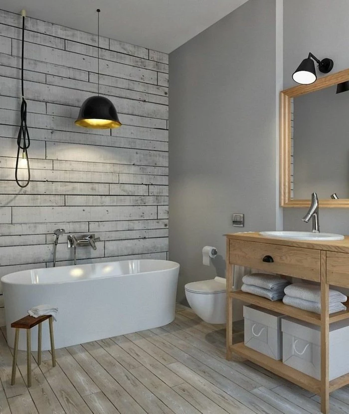 bathroom design ideas, pale wooden floor, one wall painted grey, opposite wall decorated with grayish-white wooden planks, white ceramic tub and sink
