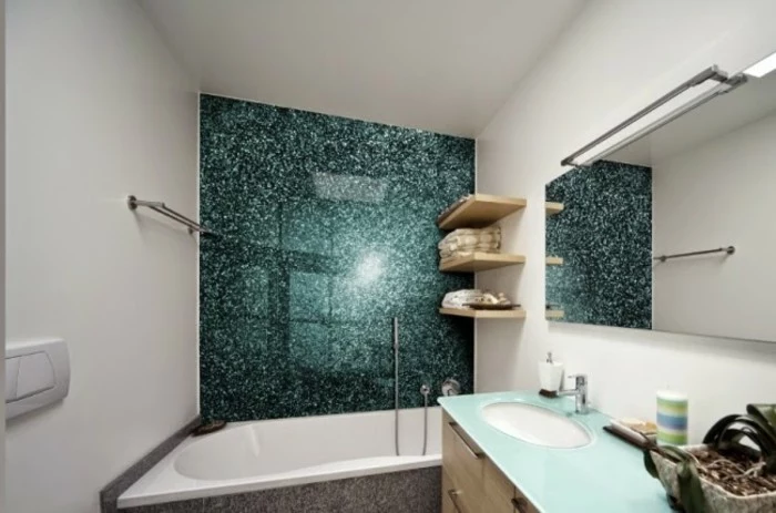 bathroom designs, inbuilt tub near a blue-green-shining wall-panel, white walls and a mirror