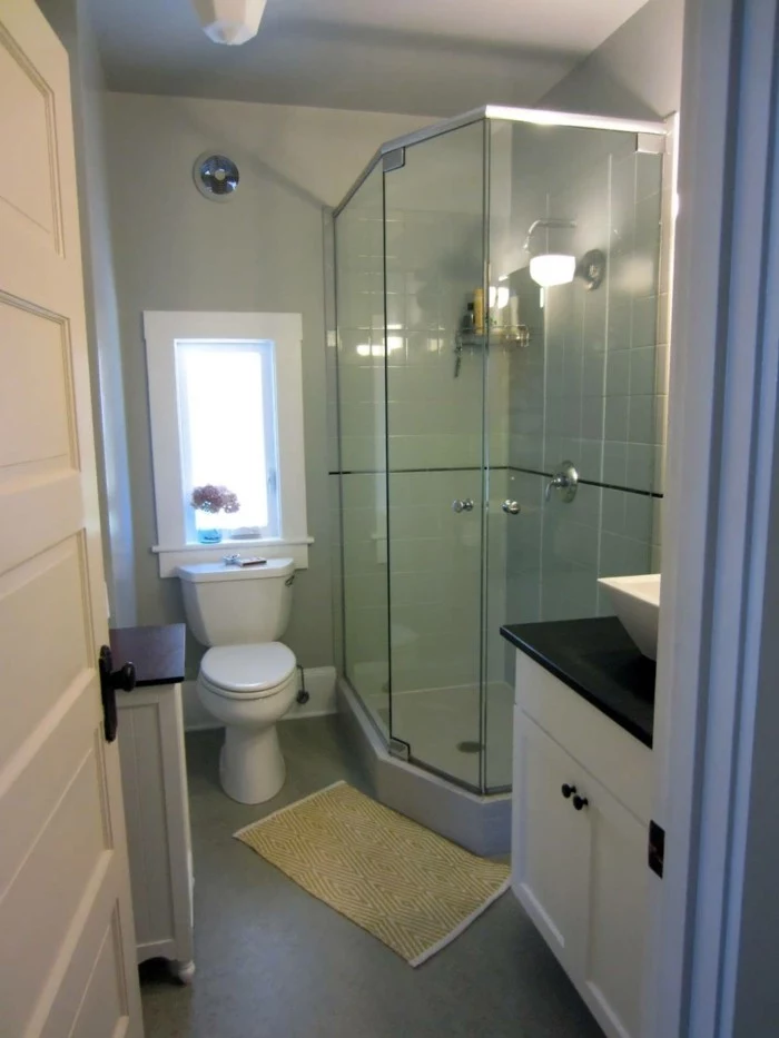 bathroom renovations, pale gray walls, glass shower cabin, white toilet and cupboards