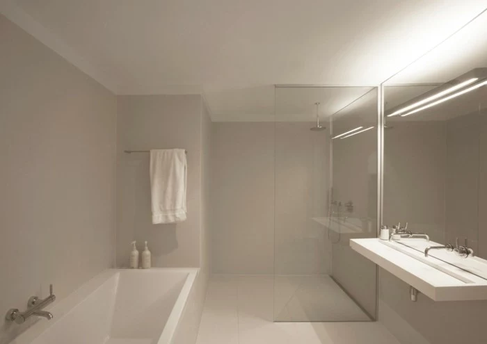 remodeling ideas, white ceiling and light cream walls and floor tiles, white bath and large sink with two water taps, big wall mirror and glass divide