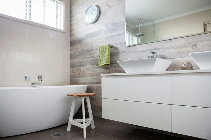 bathroom renovations, white ceramic tub, white cupboard with two ceramic sinks, brown tiled floor