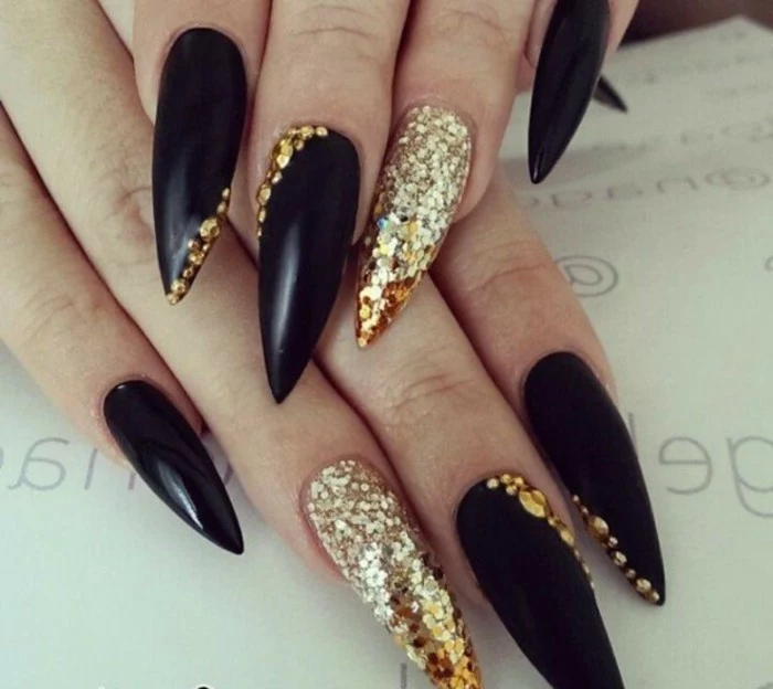 rhinestone nail art, long and sharp black nails with gold details, ring fingers' nails fully covered in golden glitter