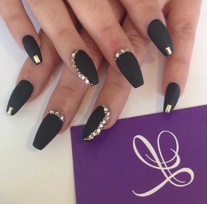 bling nail designs, two hands with black matte nail polish, decorated with gold rhinestones on each finger