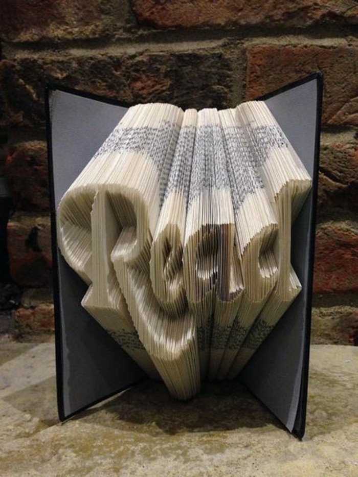 book folding, opened book with grey and black hard covers, containing the word read in fancy writing, created from folded pages