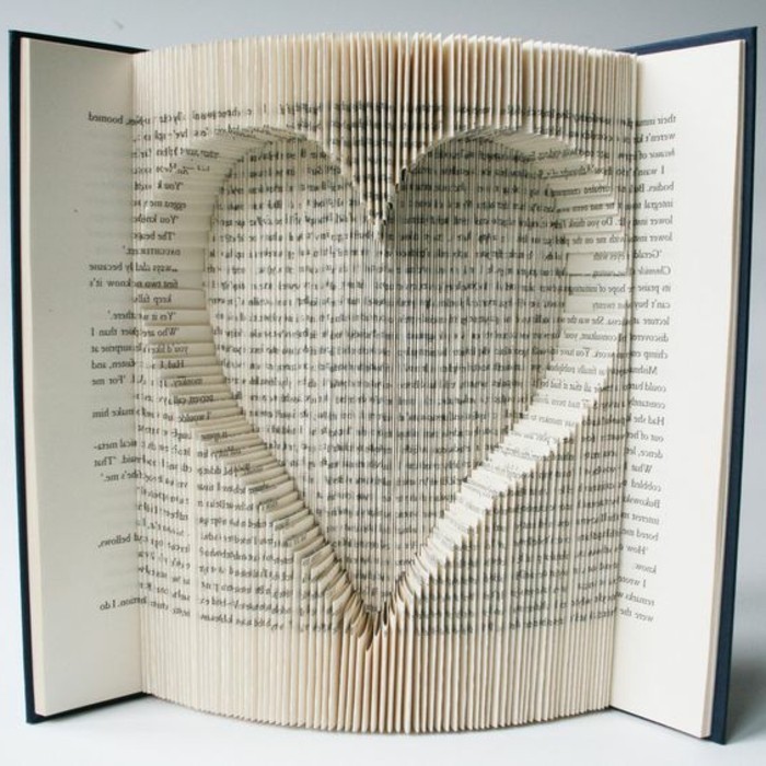 book folding, book with black hard covers, opened to reveal heart shape, made from cut and folded pages