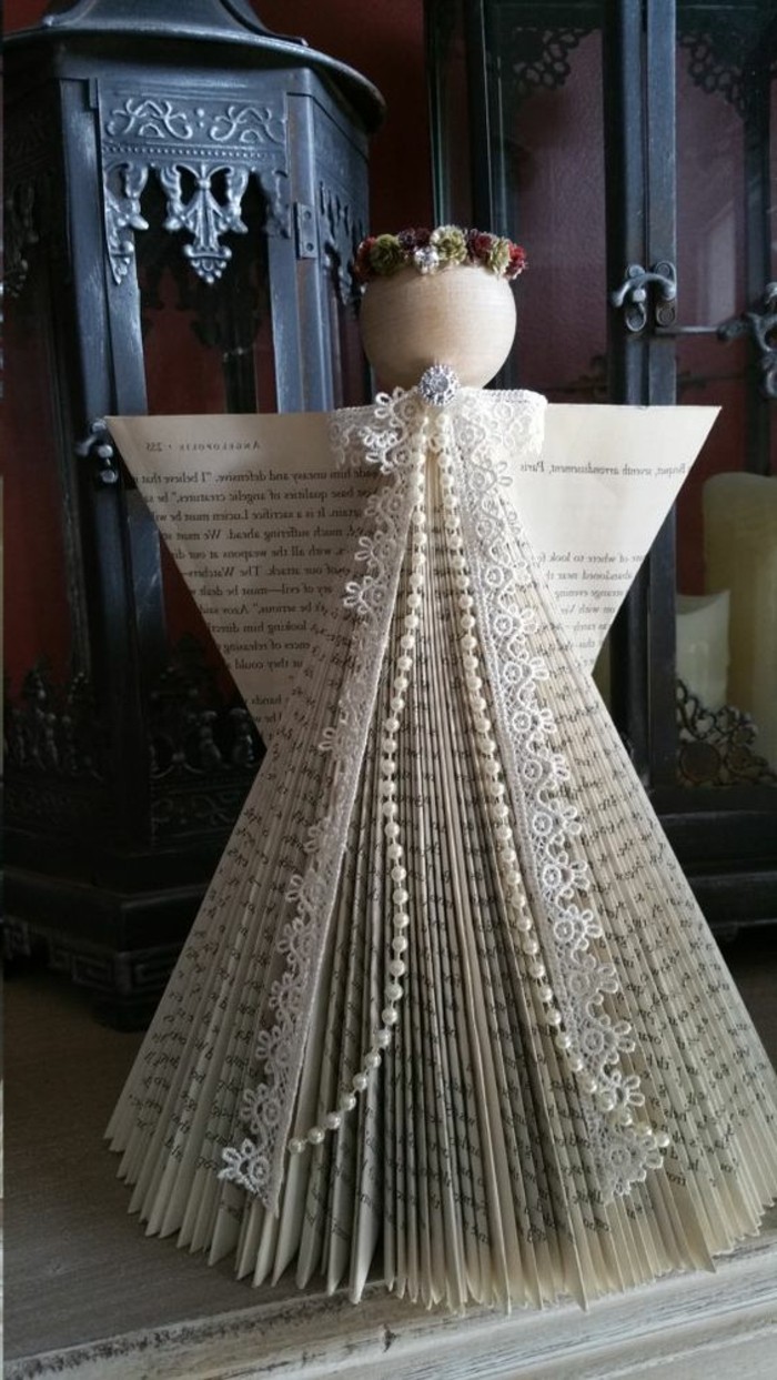 book folding patterns, angel shape made from cut and folded book pages, decorated with lace and pearl beads, with a round wooden head, and a faux flower crown