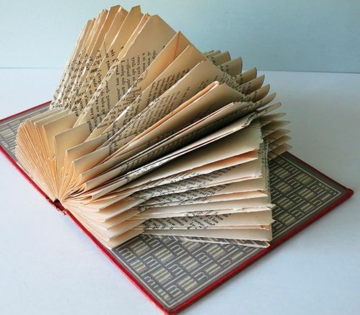 book folding, open book with red hard covers, featuring a grey and white pattern, displaying pages folded into a geometric, lantern-like shape