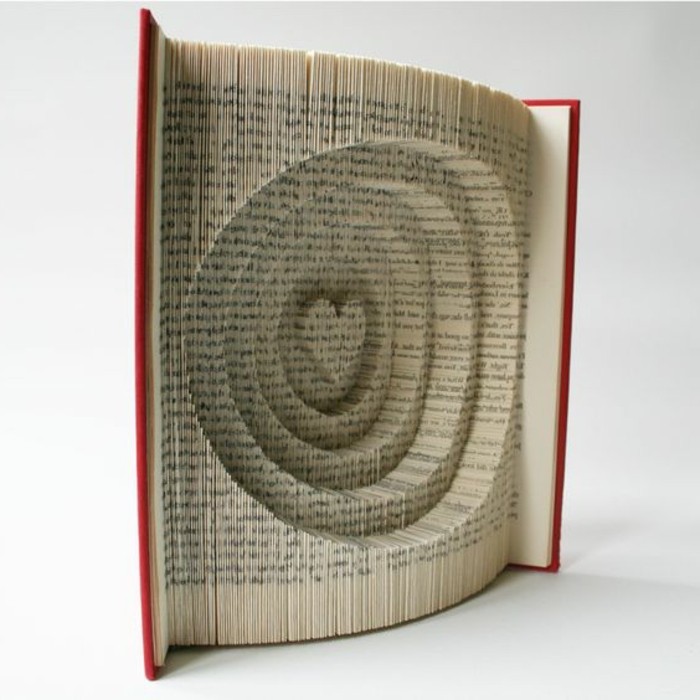 book with red hard covers, opened to reveal pages, folded to make several circles, with a heart shape in the middle