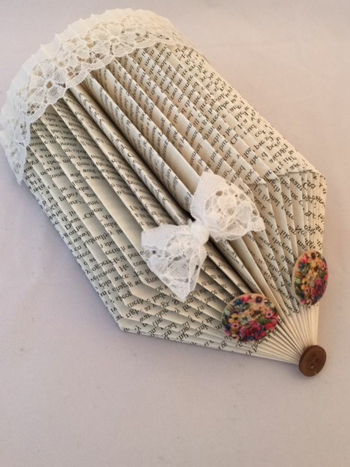 book folding art, hedgehog made from cut and folded book pages, decorated with lace trim and bow, with floral buttons for eyes, and a small brown button for nose