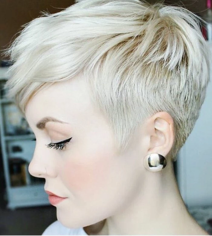 short haircuts, platinum blonde woman in profile, with hair cut short on the sides and long bangs, black eyeliner and big golden earrings