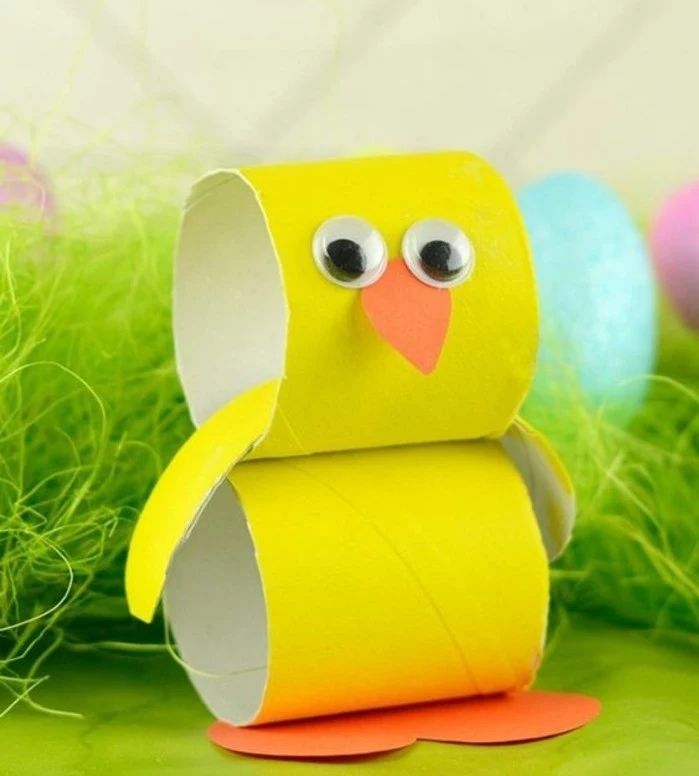 craft ideas for kids, chicken ornament made from yellow toilet paper roll, decorated with orange paper cutouts and stick-on eyes