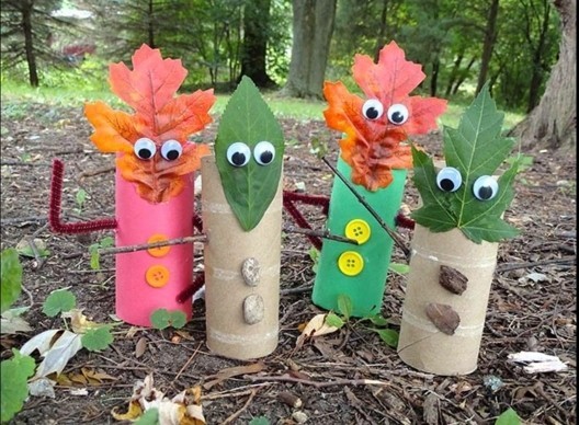 cool things to make at home, three dolls made from toilet paper rolls, with autumn leaves as heads, decorated with buttons, stones and stick-on eyes