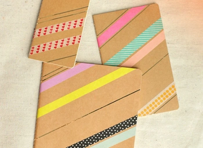 diy gifts for friends, three journals in different sizes, with cardboard covers, decorated with colorful, patterned masking tape and golden lines