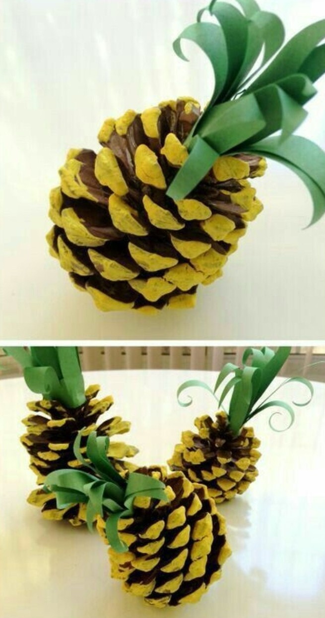 several pineapple ornaments made from a pinecone, painted in yellow, decorated with green paper leaves