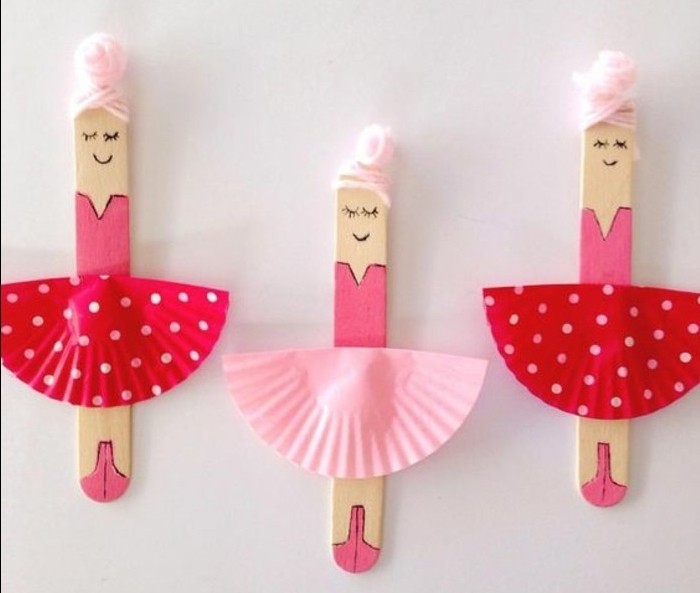 three ice cream sticks, painted to look like ballerinas, with pale pink thread for hair, and skirts made from paper muffin moulds in two shades of pink