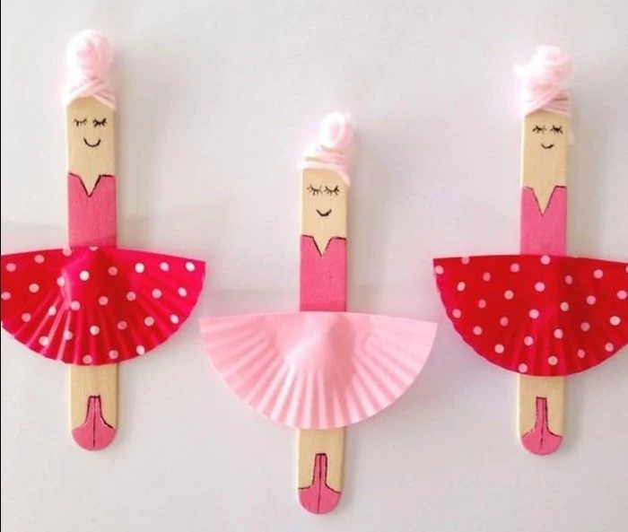 three ice cream sticks, painted to look like ballerinas, with pale pink thread for hair, and skirts made from paper muffin moulds in two shades of pink