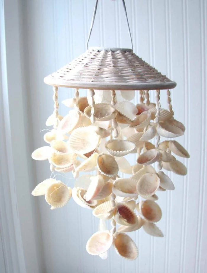 diys to do with friends, wind chime made from many, big and small white seashells, attached to a white whicker handle