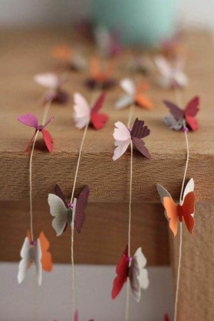 diys to do with friends, four garlands made from burlap thread, decorated with felt butterfly shapes in orange, grey and purple, pink and red