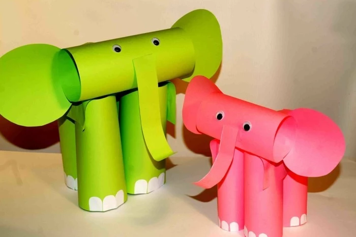 two elephants made from green and pink paper, folded in cylinders, decorated with white paper details and stick-on eyes