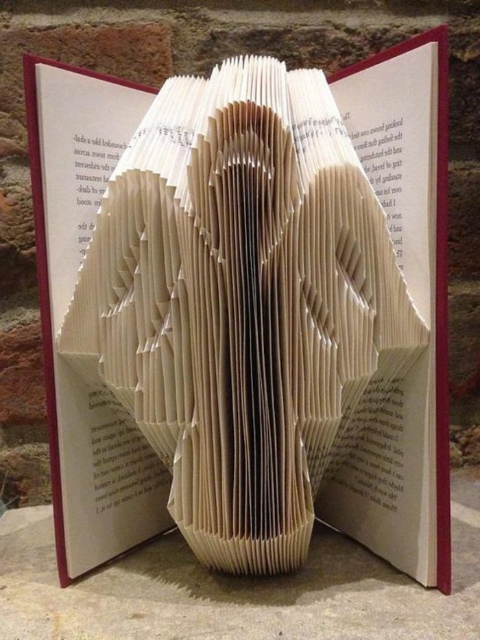 folded book patterns, simple angel shape, made from folded pages, inside an open book, with red hard covers