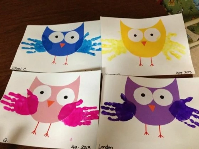 four pieces of white paper with owl collages in different colors, decorated with paper details and children's handprints