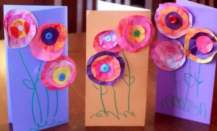 three cards made from violet and orange paper, decorated with paper flowers, made from crumpled hand-painted paper, decorated with buttons and crayon scribbles