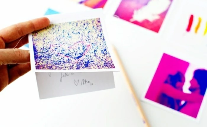 cool gifts for teens, hand holding abstract card made from polaroid photo, more photos and a paint brush blurred in the background