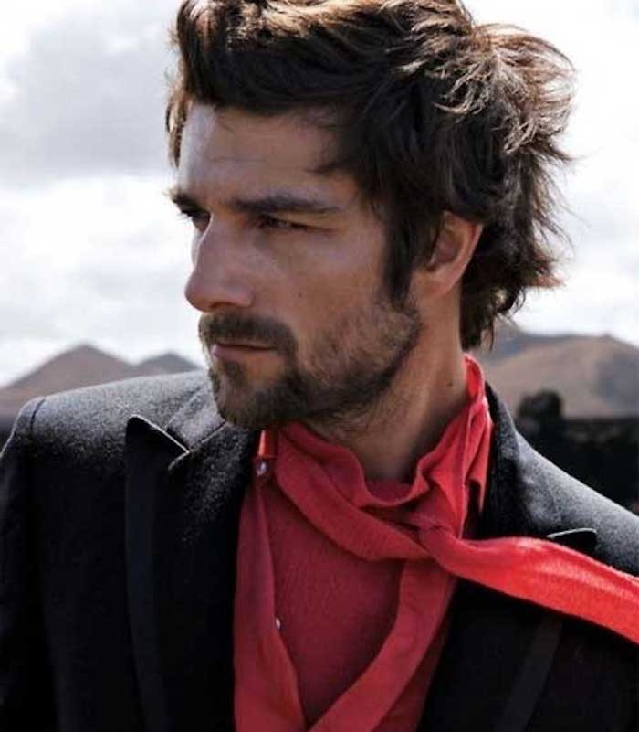 shoulder length hairstyles, man with shaggy messy hair, wearing black blazer, red shirt and scarf