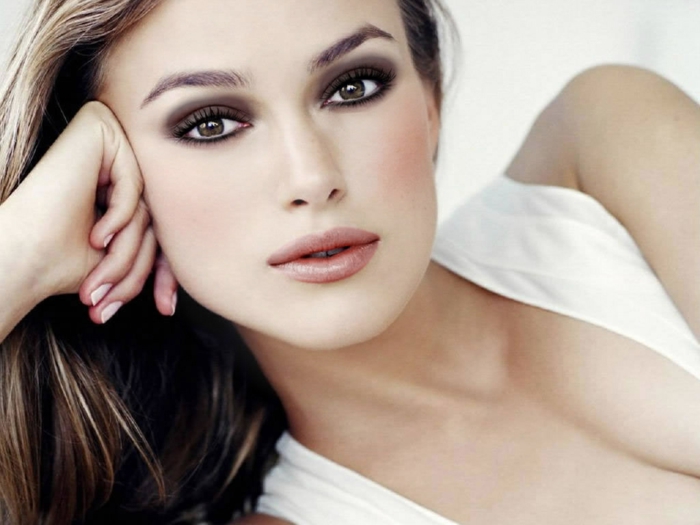 hazel eyes, close up of keira knightley, leaning on one arm, white top and brown hair, natural lipstick and smokey eye make up