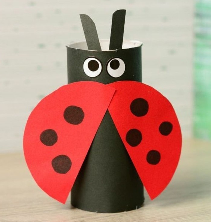 diy projects for kids, ladybug ornament made from black and red paper, decorated with stick-on eyes 