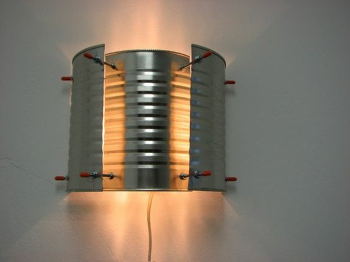 tin cans for crafts, wall lamp made from cut-up tin, pieces fixed with small red metal nails, light pouring from it