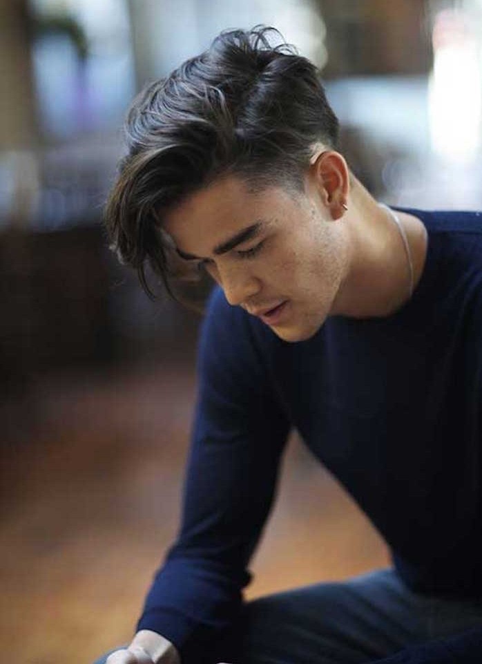 medium length hair, asian man clad in blue facing down, with undercut hairstyle, long bangs and short faded side