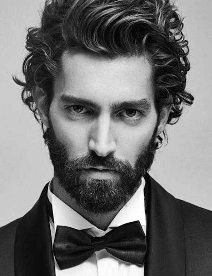 mid length hair, formally dressed man, in tuxedo and bowtie, curly dark hair swept to one side