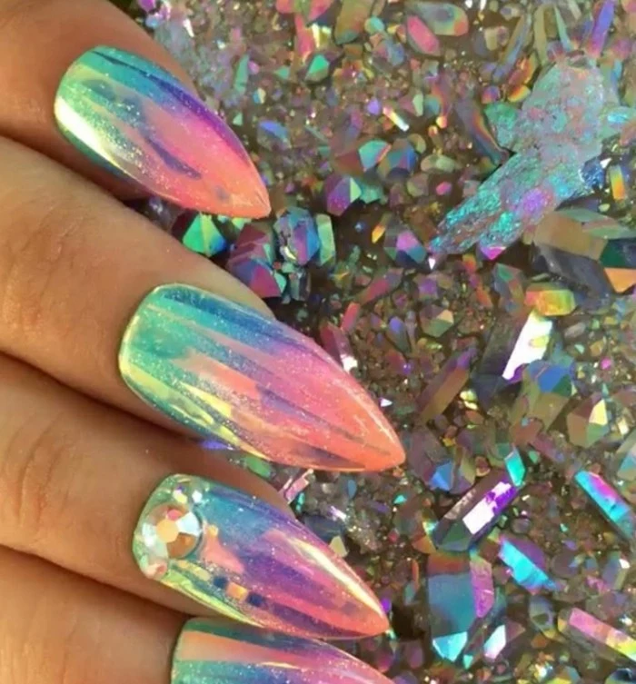 sharp mermaid nails, painted in iridescent nail polish and decorated with rhinestones