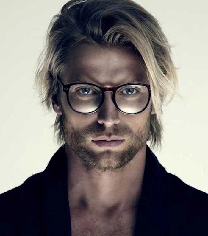 shoulder length haircuts, blond man with layered messy hair, wearing glasses and a dark jumper