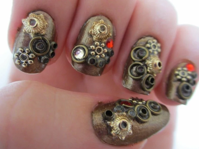 nail designs with rhinestones, five fingers with metallic nail polish, decorated with steampunk details, tiny gears and stones 