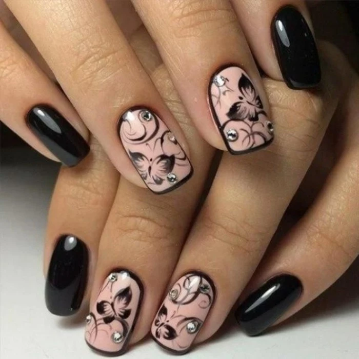 bling bling nails, eight fingers with nails painted in black and pink, pink nails have black butterfly decorations and rhinestones