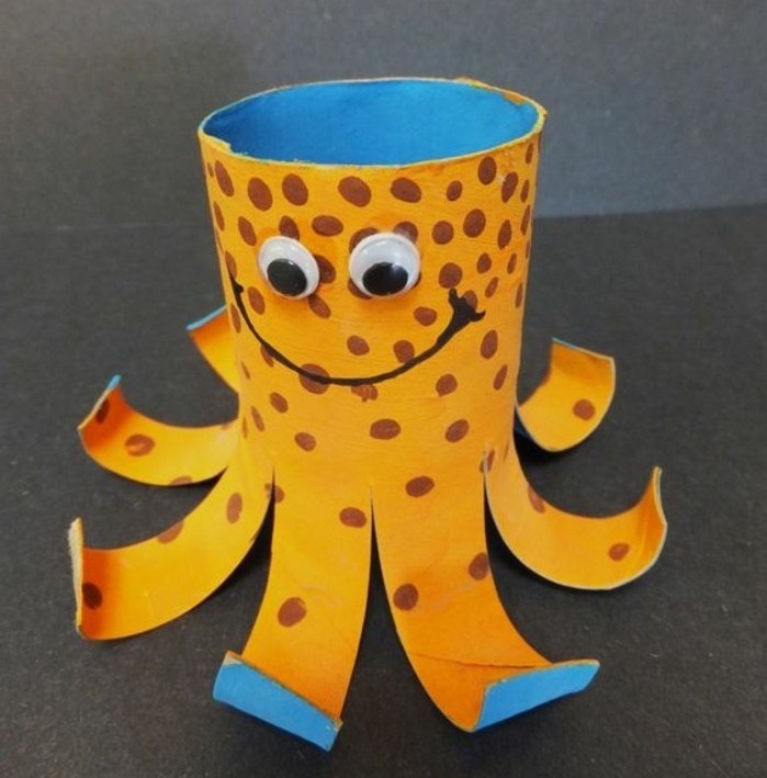 smiling octopus ornament, made from a toilet roll, painted in orange and blue, and decorated with marker and stuck-on eyes