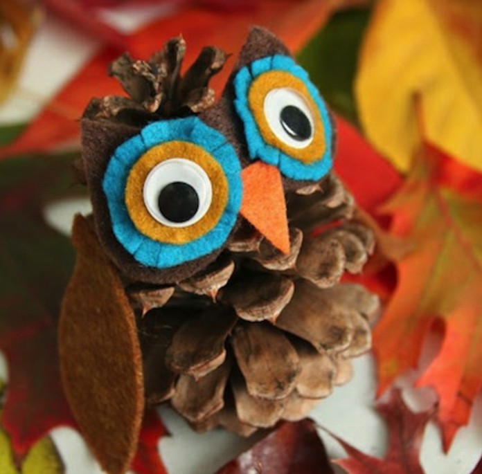 fun art projects, little owl ornament made from a pinecone, decorated with felt in different colors, with stick on eyes