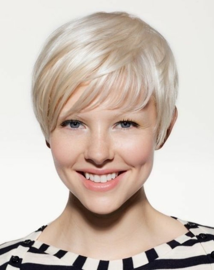 hairstyles for short hair, smiling woman with short platinum blonde pixie cut, blue eyes and natural-looking make up, wearing striped top
