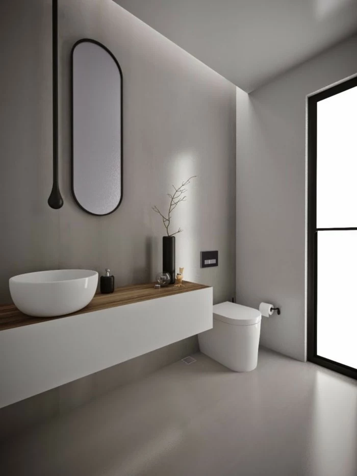 bathroom ideas photo gallery, minimalist style with light walls and floor, oval wall mirror, white ceramic toilet and sink, large window with black frames